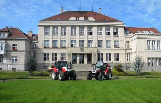 Hlavní budova školy s traktory před vchodem